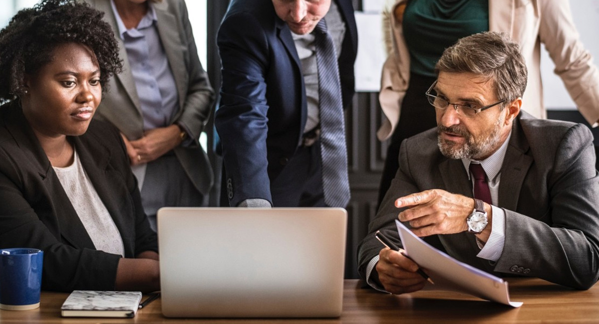 A group of people gathered around a laptop