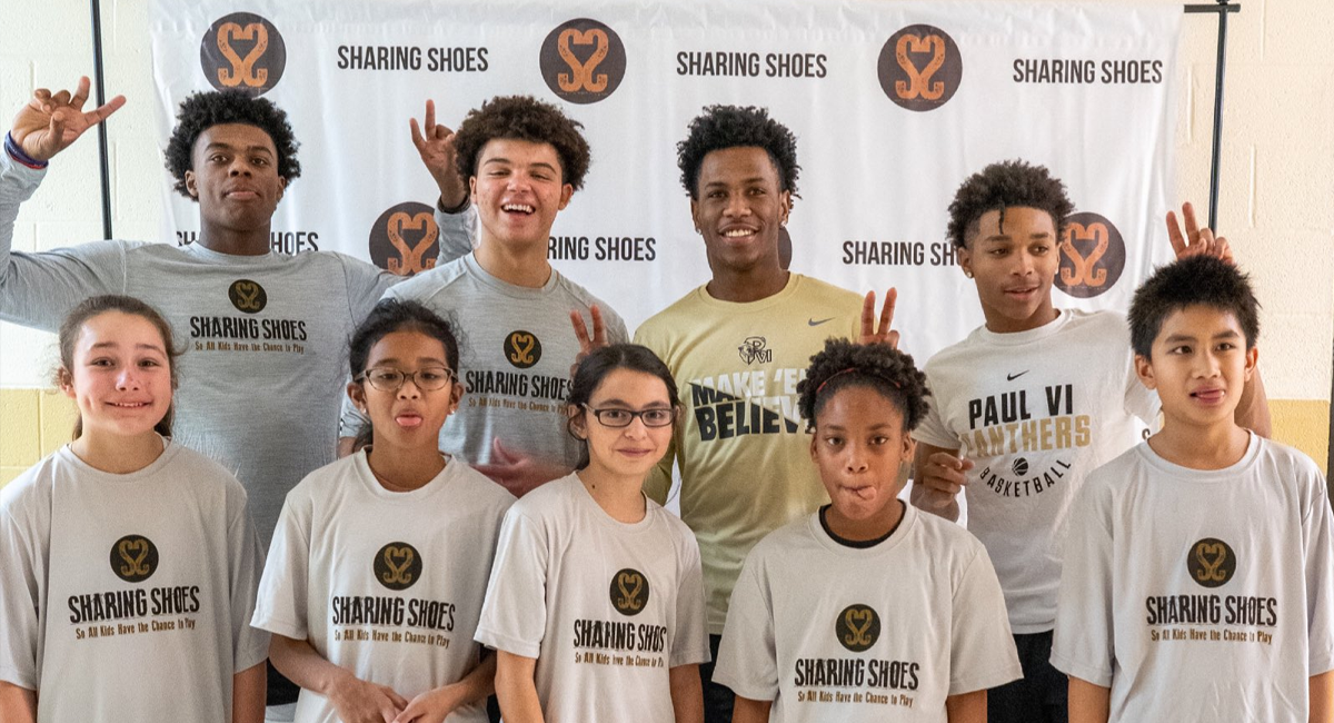 Group photo of student-atheletes wearing Sharing Shoes T-shirts.